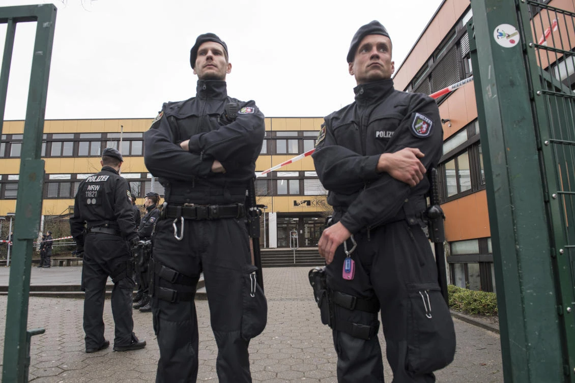 Police guard the entrance of a school in Luenen after a student was killed by a fellow pupil at a school in western Germany. (dpa via AP)