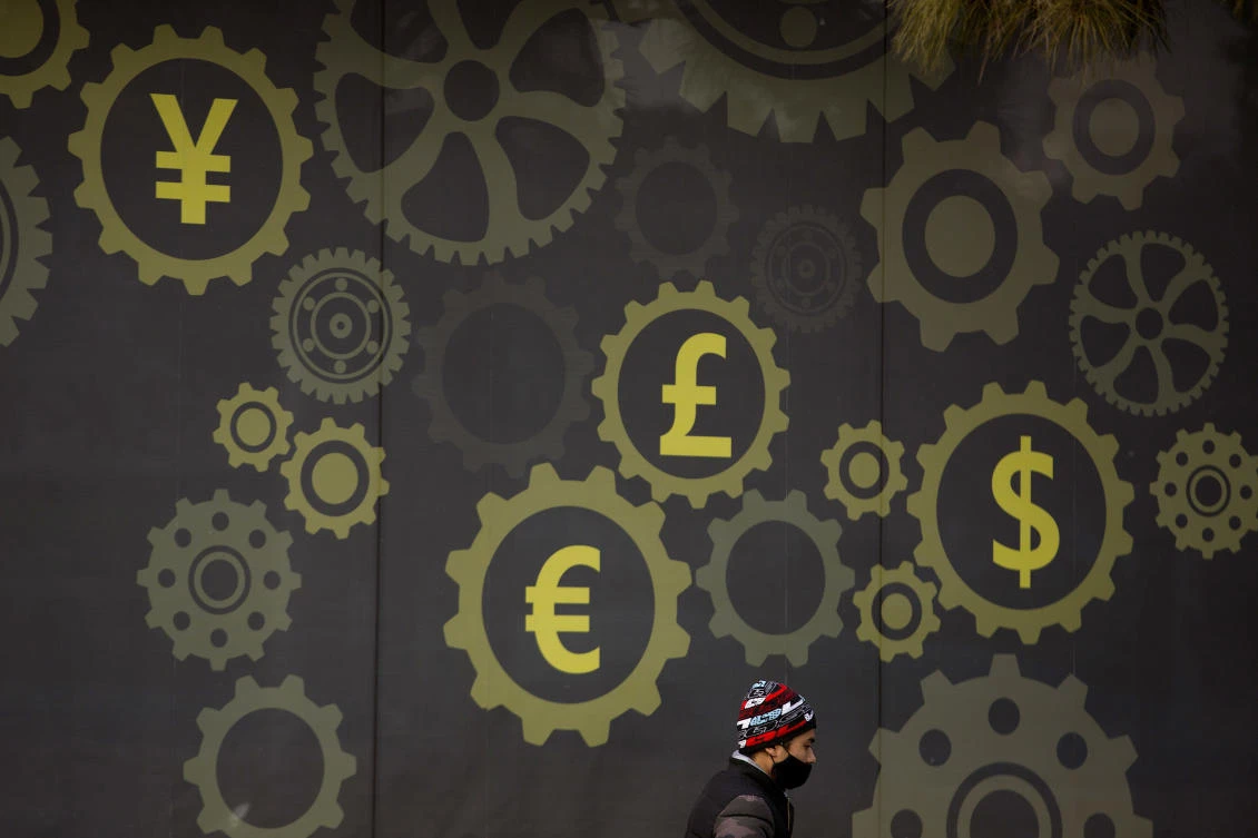 A man walks past a display showing symbols for world currencies on the exterior of a bank in Beijing. The rise of debt in China was among the issues raised at the World Economic Forum in the Swiss reosrt of Davos yesterday. (AP)