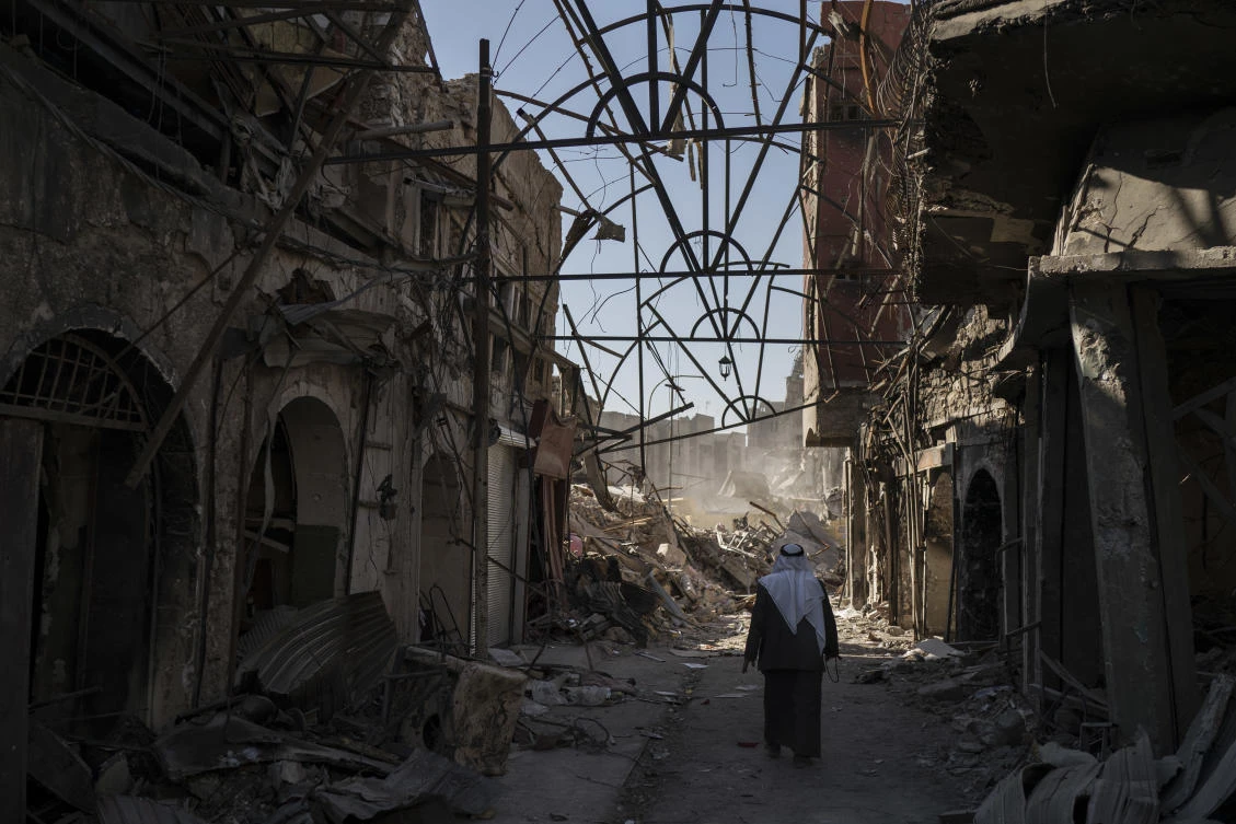 A man walks between destroyed shops in the Old City of Mosul. Iraqi officials say the most urgent priority is to rebuild housing and infrastructure to allow the more than 2 million people displaced by the conflict to return home. (AP)