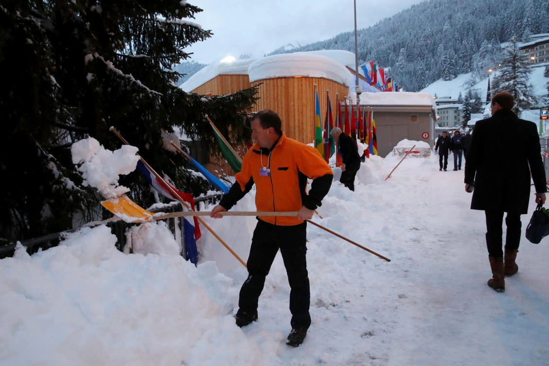 A member of staff removes snow during the World Economic Forum (WEF) annual meeting in Davos where the networking never stops. (Reuters)