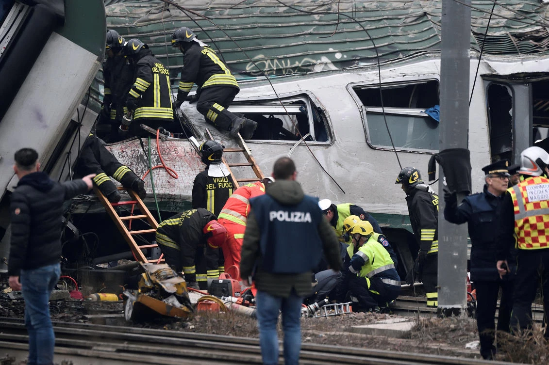 Fire fighters and police officers work around derailed trains in Pioltello, on the outskirts of Milan (Reuters)