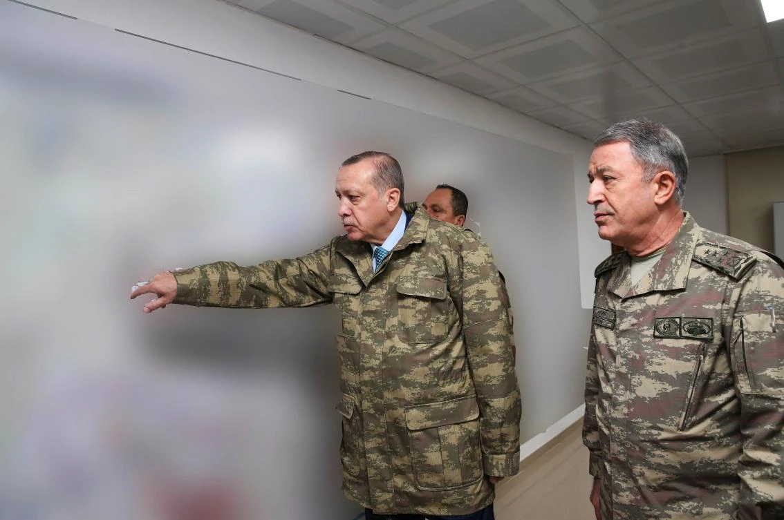 Turkey’s President Recep Tayyip Erdogan, left, gestures during a briefing led by Chief of the General Staff of the Turkish Armed Forces Hulusi at the Operating Base in Hatay in this handout photo, with blurred classified information, taken on Thursday, January 25. (Turkish Presidential Press Service via AFP)