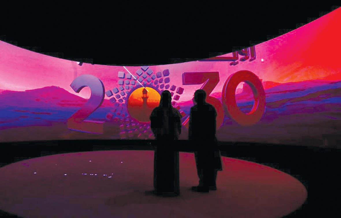 People watch a presentation on 'Neom', a vast new development planned for Saudi Arabia, which is investing heavily in renewable energy as part of the Vision 2030 economic blueprint
