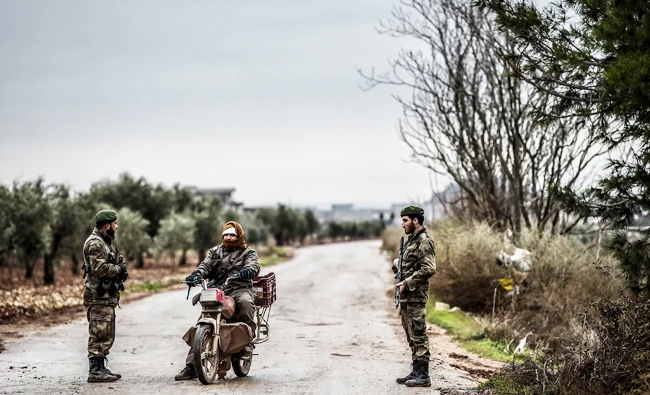 A Turkish-backed Syrian rebel fighter stops a armed man near the frontline on January 26, 2018 at the Syrian town of Azaz. (AFP)