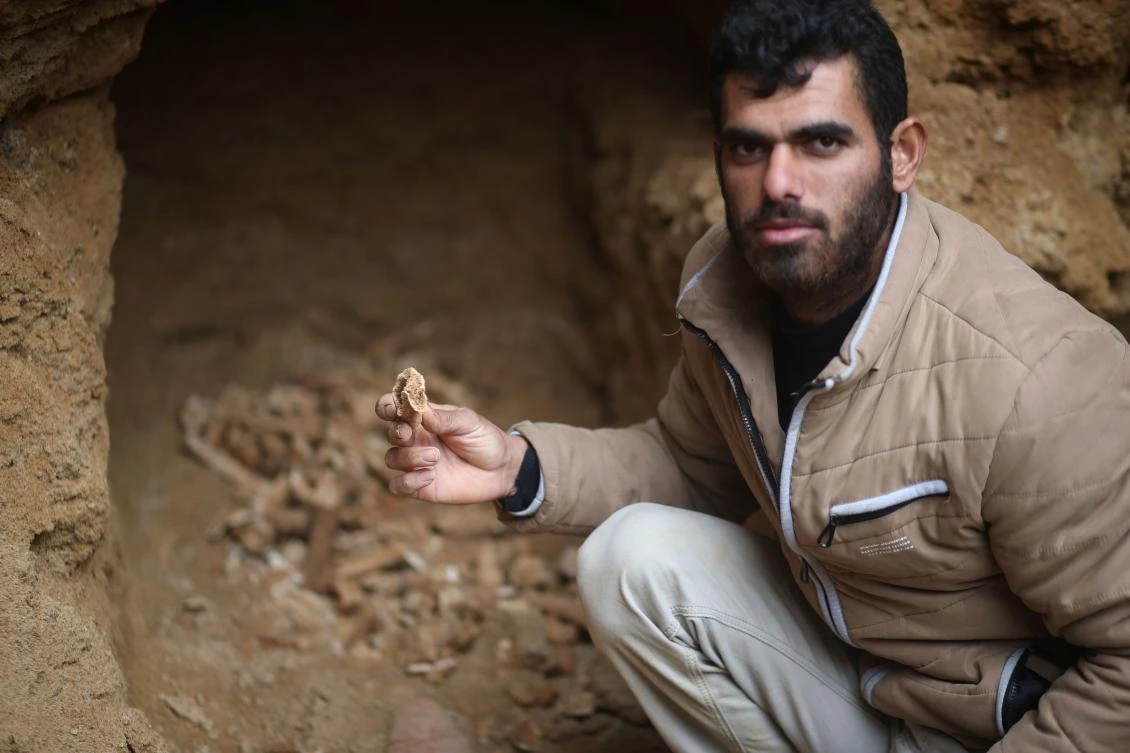 Abdel-Karim Cafran, a Palestinian resident of Beit Hanun, holds a pottery fragment at a freshly-discovered cemetery in the garden of his house in the town in the northern Gaza Strip, on Jan. 26, 2018. (AFP)