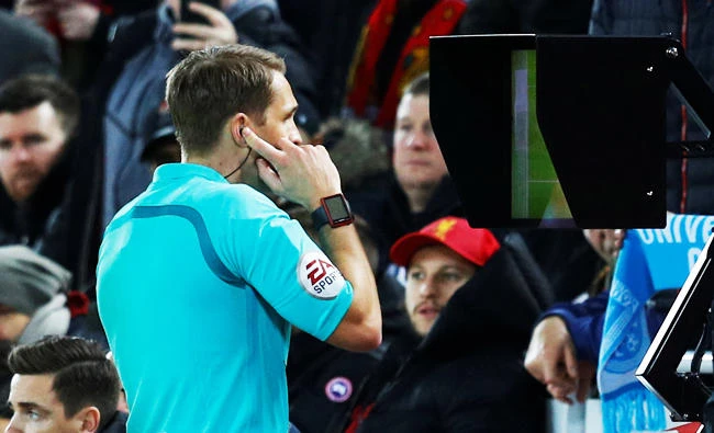 Referee Craig Pawson watches a monitor before awarding a penalty to Liverpool upon VAR (Video Assistant Referee) review. (Reuters)
