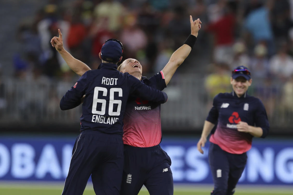 England's Tom Curran, center, celebrates with Joe Root after taking the Australian's final wicket during their one day international cricket match in Perth. (AP)