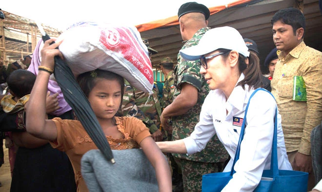 Michelle Yeoh, right, distributes blanket to a Rohingya refugee at Balukhali refugee camp near Cox's Bazar, Bangladesh. (AP)