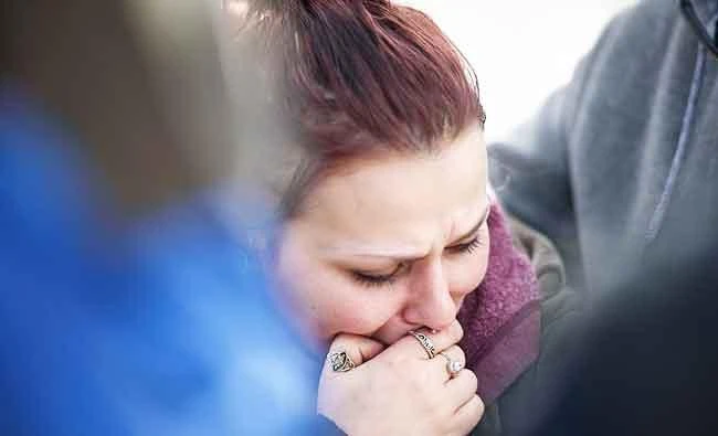 Sierra Kolarik, the sister of Chelsie Cline, one of the victims in a mass shooting at Ed's Car Wash early Sunday morning, is comforted on January 28, 2018 in Melcroft, Pennsylvania. (AFP)