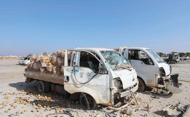 Trucks loaded with sacks of potatoes were damaged during airstrikes, which hit the vegetable market of the town of Saraqeb in Idlib. (AFP)