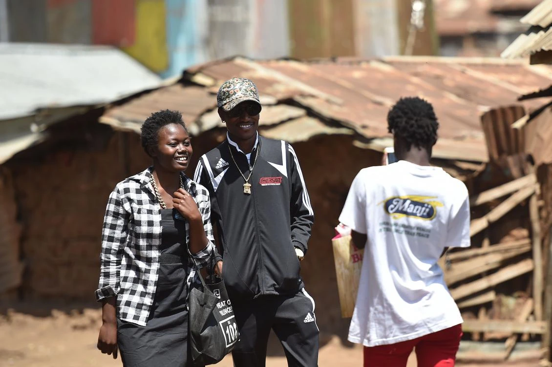 Kenyan hip hop artist Henry Ohanga (aka Octopizzo), who hails from Kenya's largest slum Kibera in Nairobi, poses with a fan during a visit to Kibera on January 16, 2018. (AFP)