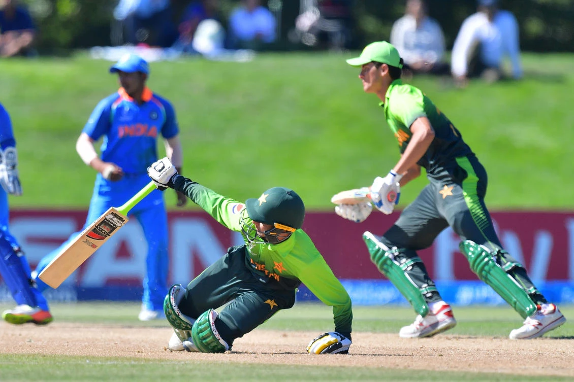 Pakistan’s Saad Khan (C) slides whilst running with teammate Shaheen Shah during the U19 semifinal cricket World Cup match between India and Pakistan at Hagley Oval in Christchurch on Jan. 30, 2018. (Marty MELVILLE / AFP)