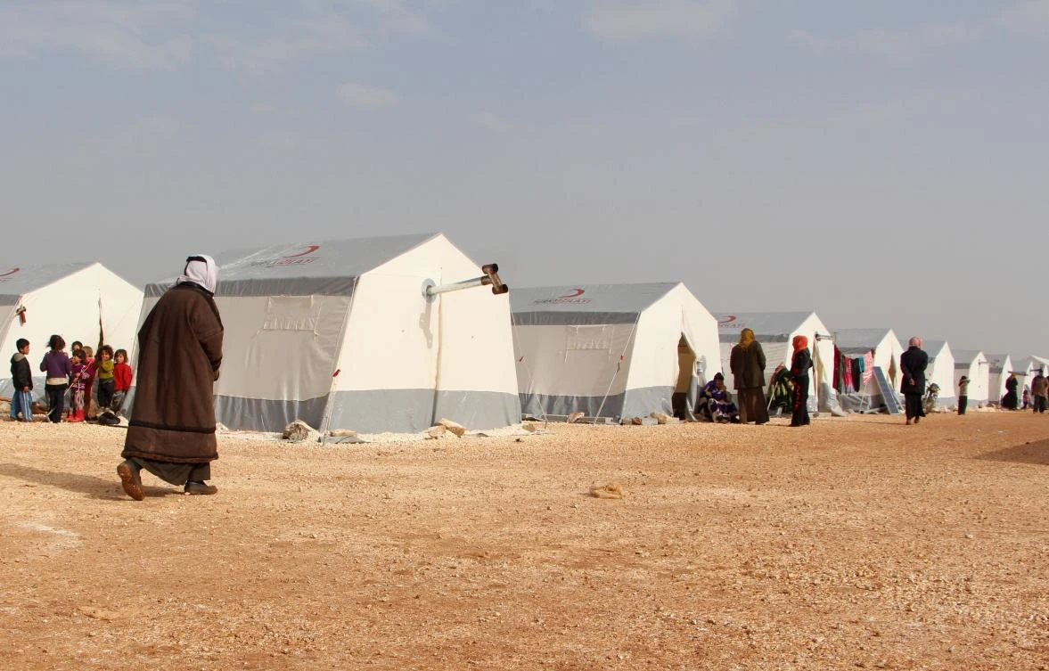 Syrians who fled from shellings in the southern Idlib and Aleppo countryside stand outside their tents at a newly-opened camp for the displaced near Bab Al-Hawa by the Syria-Turkey border. (AFP)