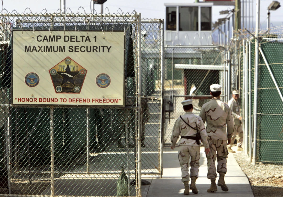 In this June 27, 2006 file photo, reviewed by a US Department of Defense official, US military guards walk within Camp Delta military-run prison, at the Guantanamo Bay US Naval Base, Cuba. (AP Photo/Brennan Linsley, File)