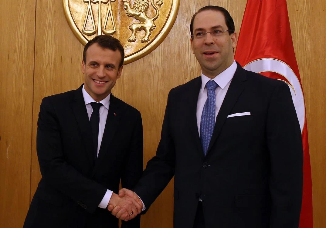 Tunisian Prime Minister Youssef Chahed (R) shakes hands with French President Emmanuel Macron during their meeting in Tunis. (AFP)