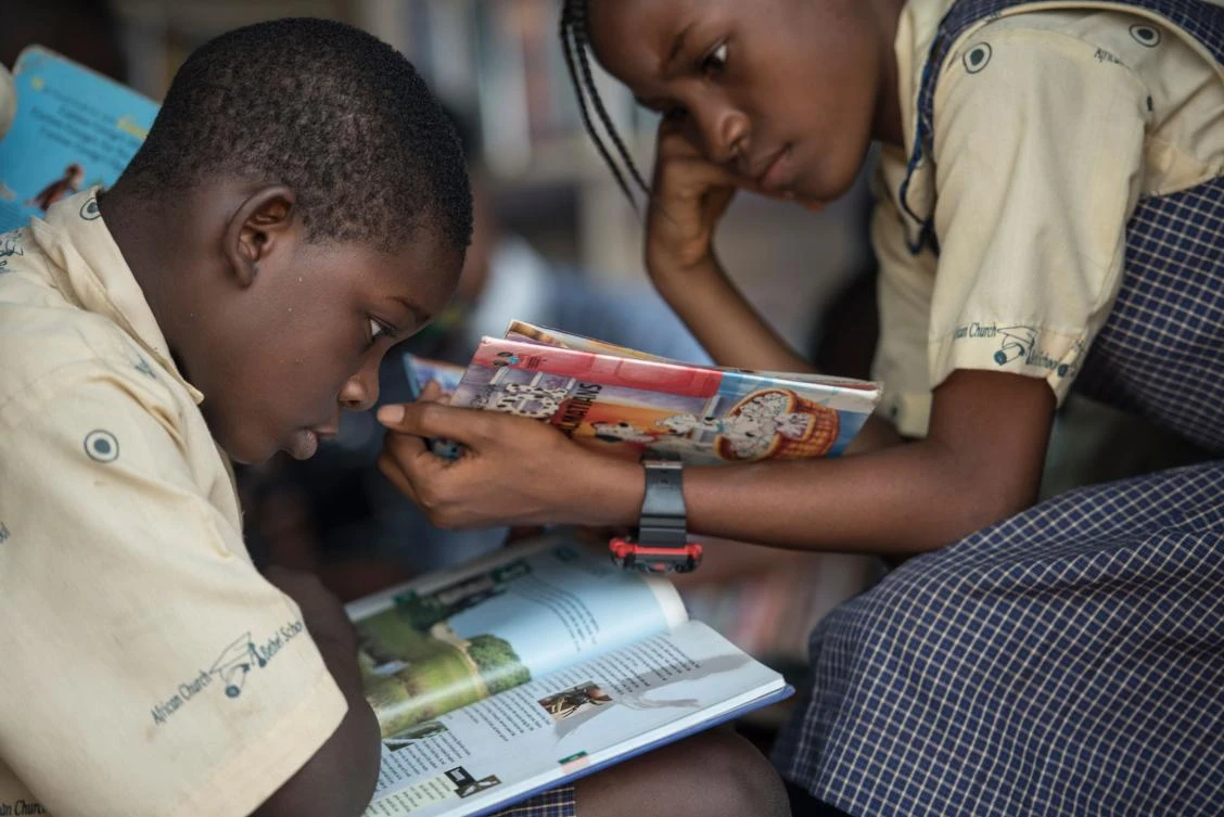 A boy and a girl sit and read books in the I-Read mobile library. The ‘mobile library’ project was launched, in 2013, by Funmi Ilori. (AFP)