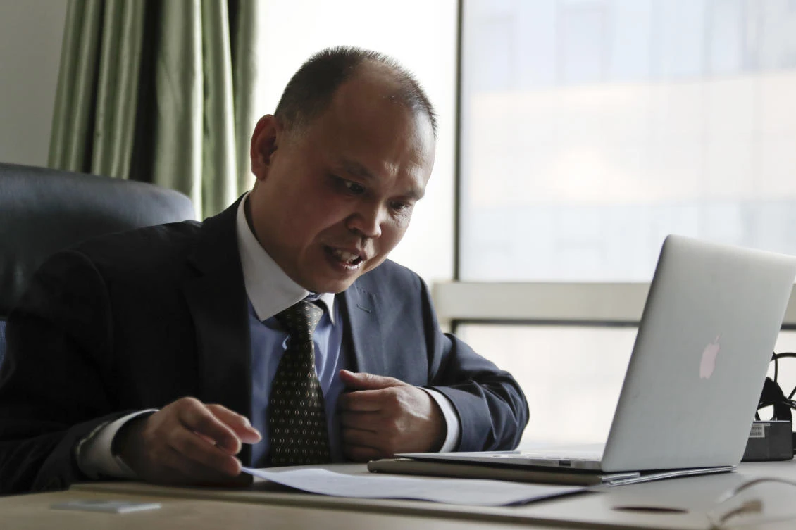 In this Feb. 24, 2017, file photo, Chinese lawyer Yu Wensheng checks on his lawsuits at his office in Beijing. The wife of a Chinese human rights lawyer says her husband was taken into police custody Friday, Jan. 19, 2018, while taking his son to school, a day after he posted a letter online calling on China’s ruling communist party to reform the Chinese constitution and allow open presidential elections. (AP Photo/Andy Wong, File)