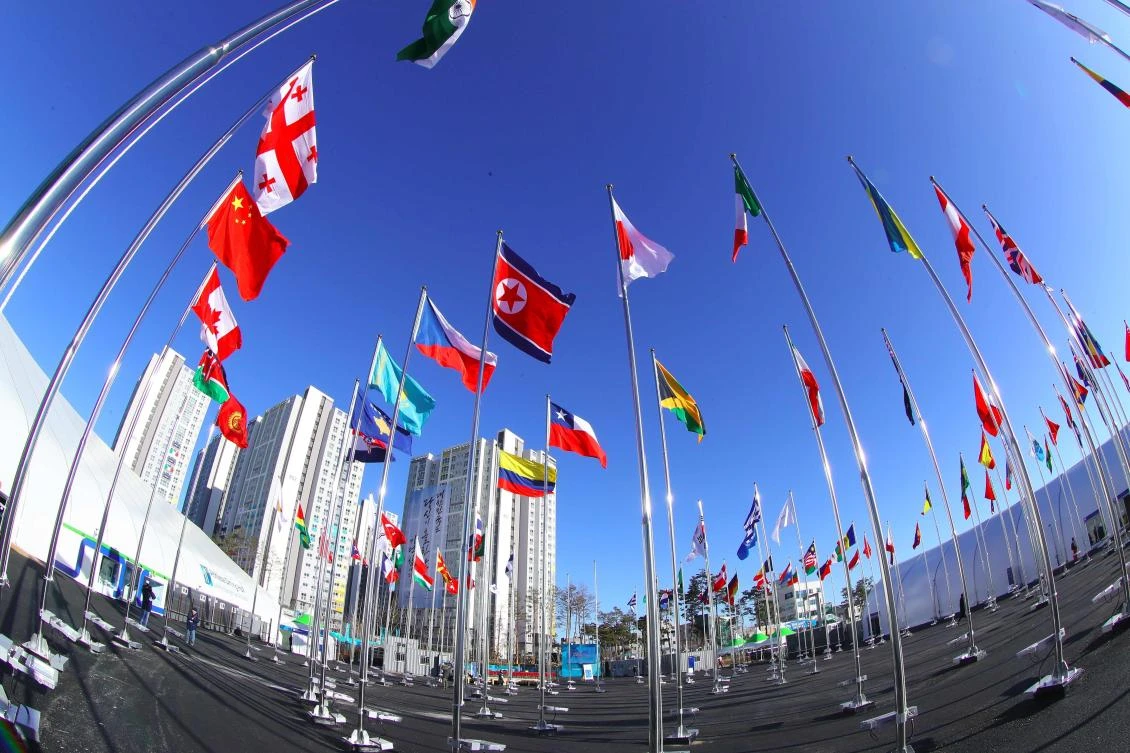 A North Korean national flag, center, and other nations’ flags flutter over the Athletes Village in Gangneung ahead of the Pyeongchang Winter Olympic Games. (Yonhap via AFP)