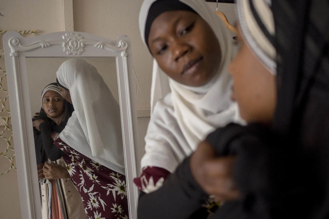 In this photo taken Monday Jan. 22, 2018, Sekina Abam a muslim hijab fashion designer helps a customer to set up a hijab in her workshop in Accra, Ghana. (AP)