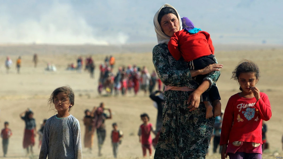 Displaced people from the minority Yazidi sect, fleeing violence from forces loyal to the Islamic State in Sinjar town, walk towards the Syrian border on the outskirts of Sinjar mountain near the Syrian border town of Elierbeh of Al-Hasakah Governorate. (REUTERS