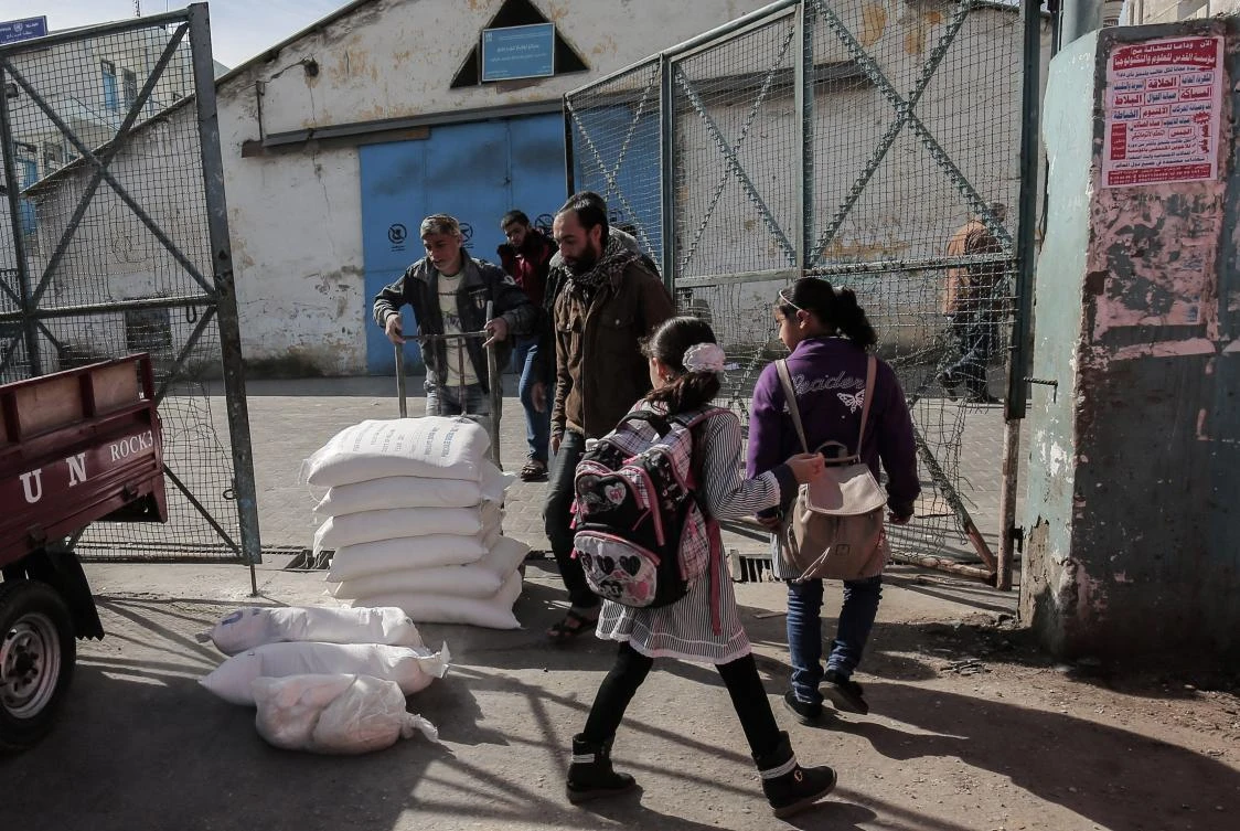 Palestinian refugees collect aid parcels at a United Nations food distribution centre in Rafah in the southern Gaza Strip on Jan. 21, 2018. (AFP)