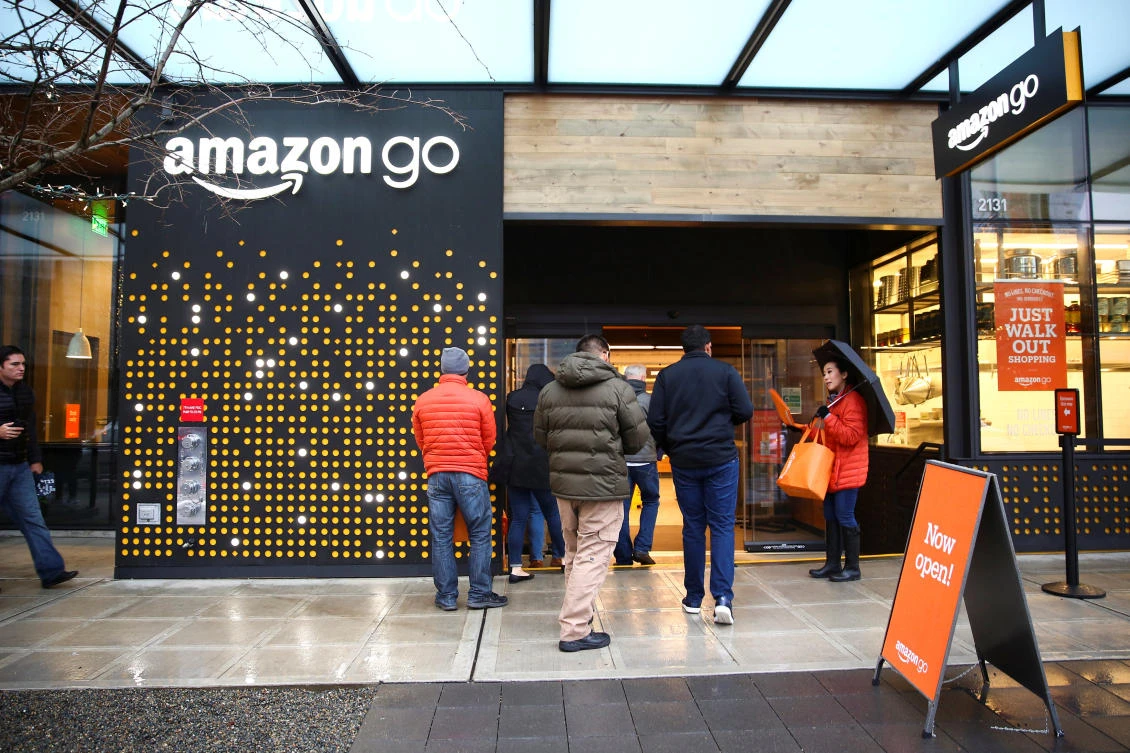Above, people are offered free reusable bags as they enter the new Amazon Go store at Amazon's Seattle headquarters in Seattle. (Reuters)
