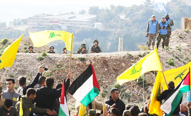 Israeli soldiers (top L) and UN peacekeepers (top R) look at Lebanese supporters of the Shiite Hezbollah movement attending a rally against the US president's decision to recognise Jerusalem as the capital of Israel, in this January 28, 2018 photo, in the southern Lebanese village of Alma al-Shaab, on the border with Israel. (AFP)