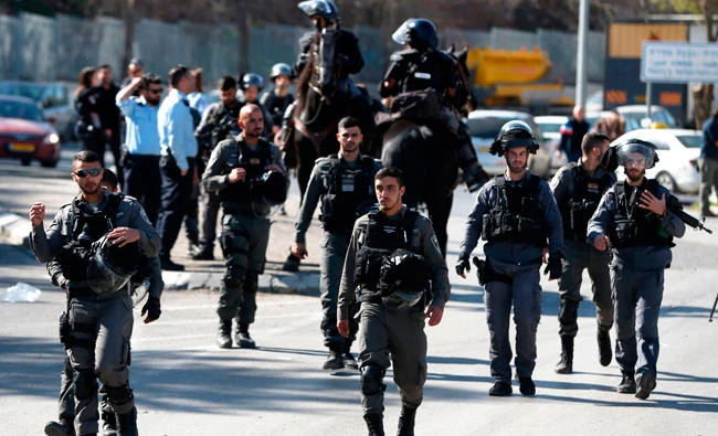 A photo taken on February 2, 2018 shows Israeli border guards walking after Friday prayers at the entrance of Issawiya, a Palestinian Arab neighbourhood in East Jerusalem, following days of clashes and arrests. (AFP)