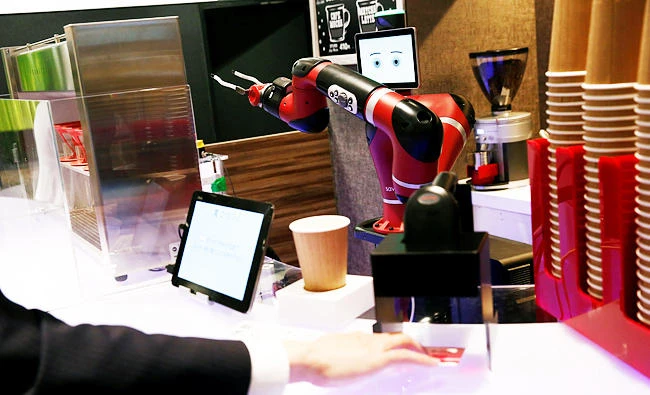 A man scans a QR code printed on a ticket used to order a coffee from the robot barista called "Sawyer" during its demonstration at "Henn-na Cafe," meaning "Strange Cafe" in Japanese, in Tokyo, Japan, in this January 30, 2018 photo. (REUTERS)