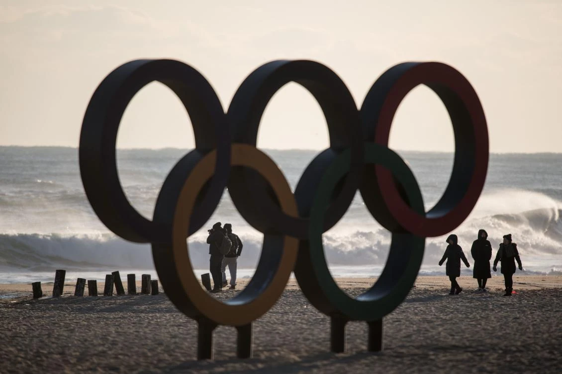 People walk before the Olympic Rings during sunrise on Gyeongpo beach in Gangneung, the host city of the ice venues for the Pyeongchang 2018 Winter Olympic Games, on February 5, 2018. (AFP)