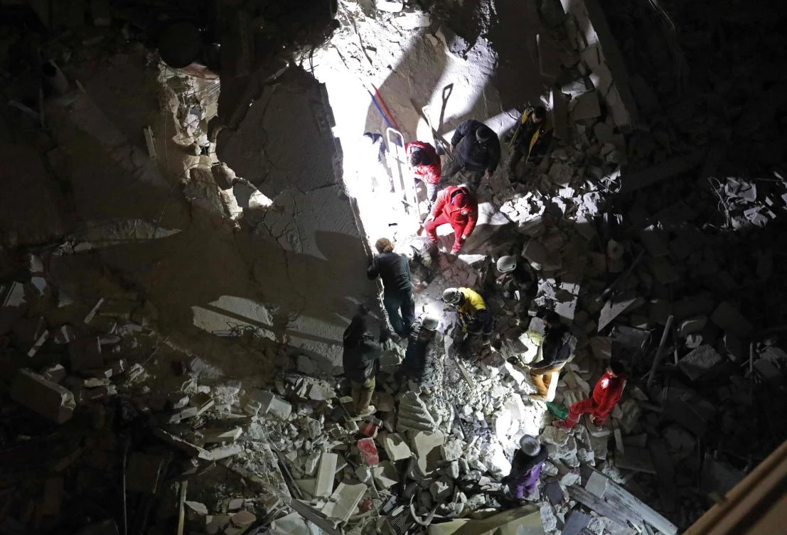 Syrian emergency services search for members of four families reportedly stuck under the rubble of a six story building that collapse following Syrian government air strikes on Idlib on February 4, 2018. (AFP)