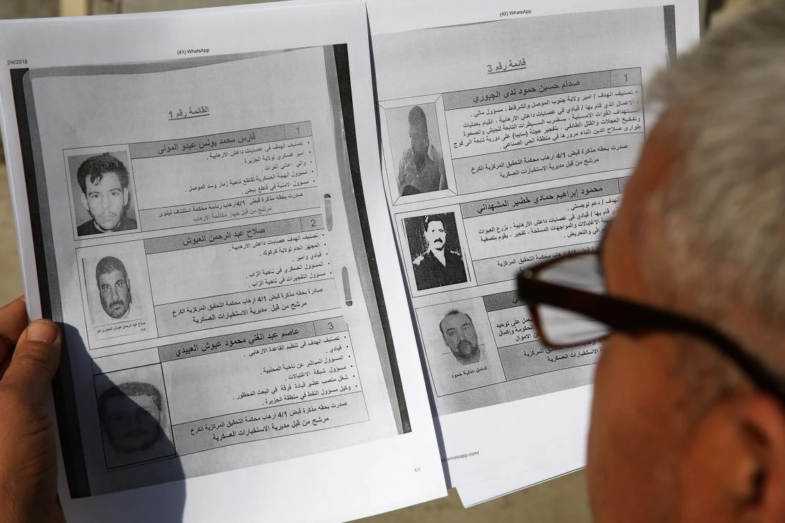 An Iraqi man looks at a list of names published for the first time by the Iraqi security services of the country’s sixty most wanted people including members from the Daesh group, Al-Qaeda and the former Baath party on Feb. 4, 2018 in Baghdad. (AFP)