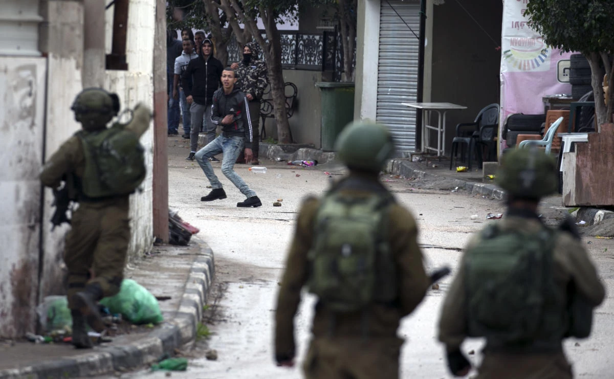 Israeli forces clash with Palestinian youths during a military operation in Jenin, in the north of the occupied West Bank, on January 18, 2018. (AFP)