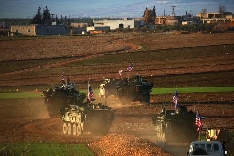 A convoy of US forces armoured vehicles drives near the village of Yalanli, on the western outskirts of the northern Syrian city of Manbij. (AFP)