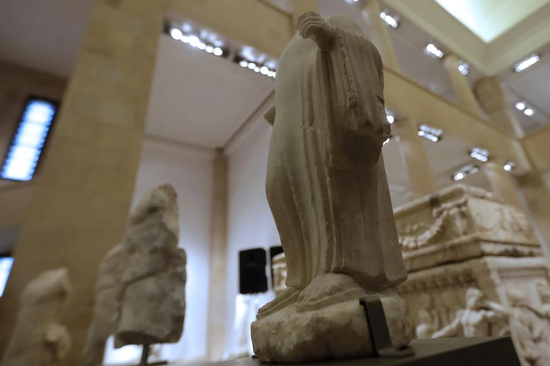 A picture taken on February 2, 2018 shows a Phoenician sculpture of a young boy wearing a long shirt dating back to the 5th century BC, part of a collection of repatriated artefacts on display during a ceremony at Beirut National Museum. (AFP)
