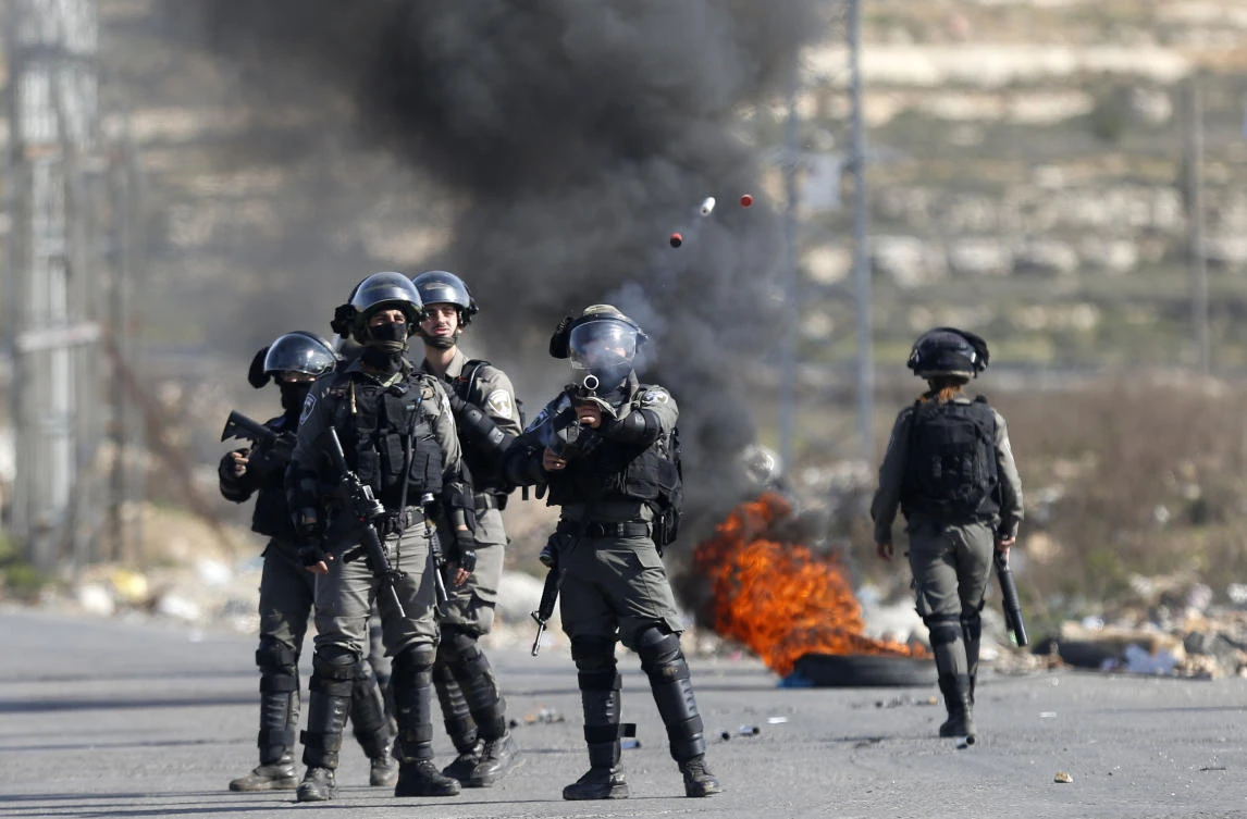 Israeli border policemen fires tear gas at Palestinians during clashes following a protests against US. (AP)