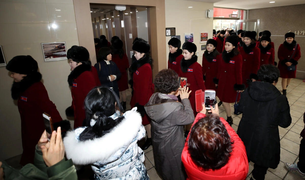South Korean people take photographs of members of the North Korean cheering squad at an expressway service area in Gapyeong. (Yonhap via Reuters)