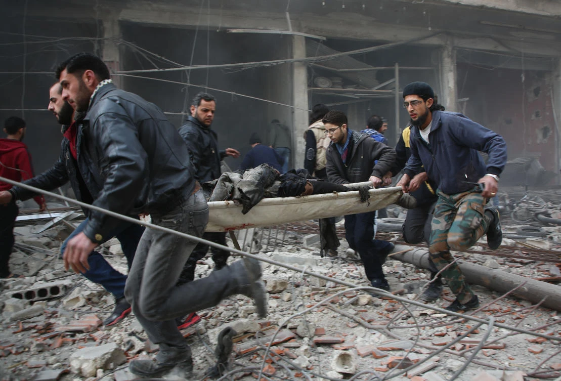 Syrian rescuers evacuate badly injured people following regime strikes on the besieged rebel-held enclave of Kafr Batna near Damascus on February 6, 2018. (AFP)