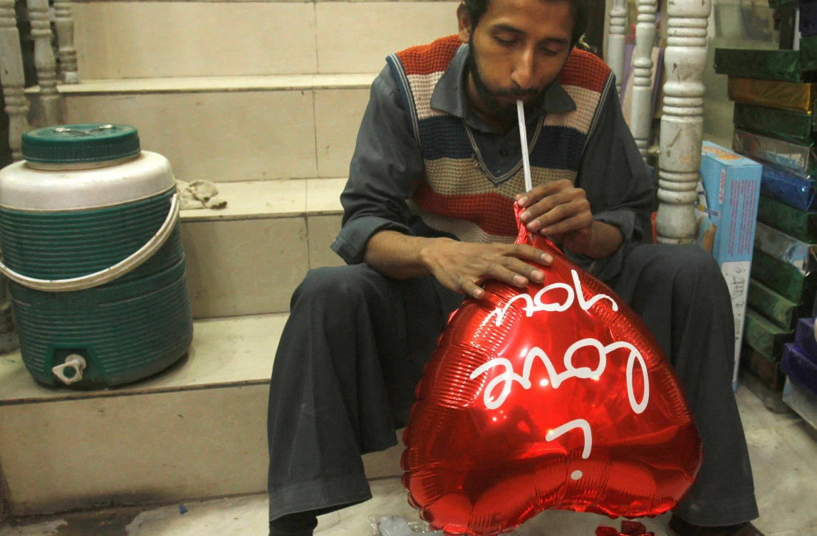 A man inflates a heart shaped balloon ahead of Valentine’s day in Peshawar, Pakistan Feb. 7, 2018. (Reuters/Fayaz Aziz)