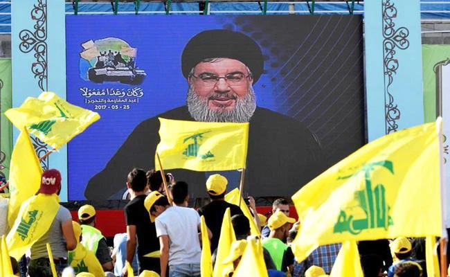 People watch Lebanon's Hezbollah leader Sayyed Hassan Nasrallah as he appears on a screen during a live broadcast to speak to his supporters in Bekaa Valley, Lebanon, on May 25, 2017. The group has been accused as a terrorist organization and a tentacle of the Iranian regime. (REUTERS file photo)