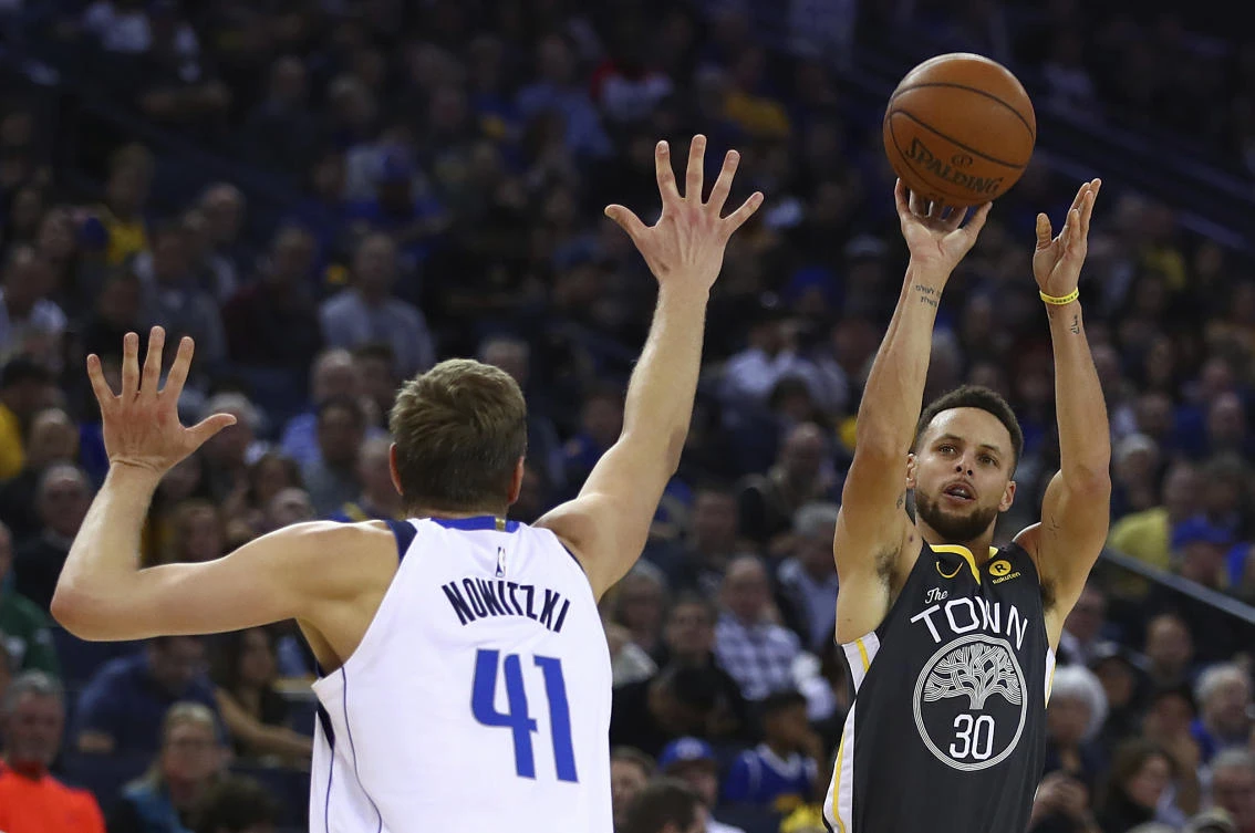 Golden State Warriors’ Stephen Curry shoots over Dallas Mavericks’ Dirk Nowitzki during the second half of their NBA basketball game on Thursday, February 8. (AP)