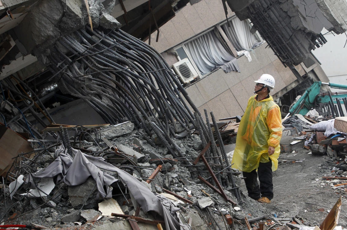 An official inspects the failed rebar foundation pillars during a continued search operation at an apartment building, which collapsed after a strong earthquake in Hualien County, eastern Taiwan. (AP)