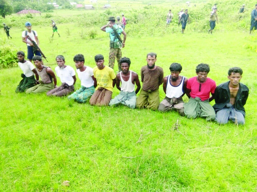 Ten Rohingya Muslim men with their hands bound kneel as members of the Myanmar security forces stand guard in Inn Din village in this Sept. 2, 2017 file photo. (Reuters)