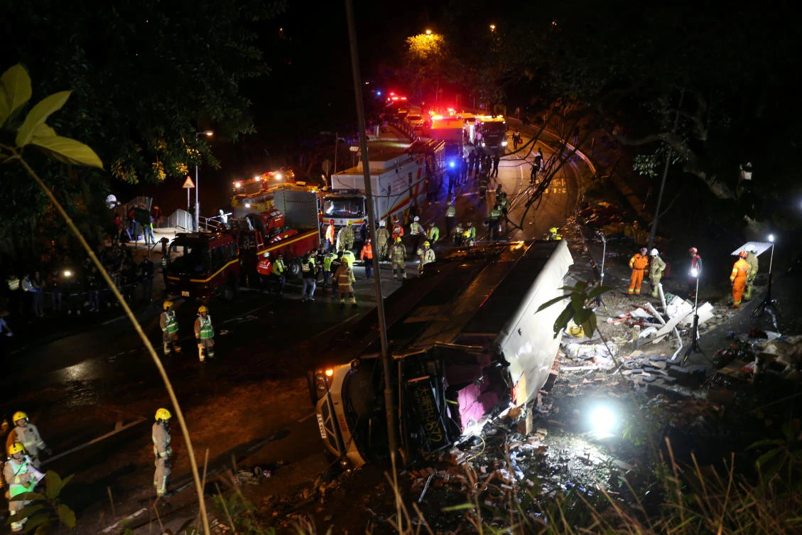 Rescuers at the site of a bus crash in Hong Kong, which cost the lives of 18 people. The bus driver was arrested and charged with causing death and grievous bodily harm by dangerous driving. (Reuters)