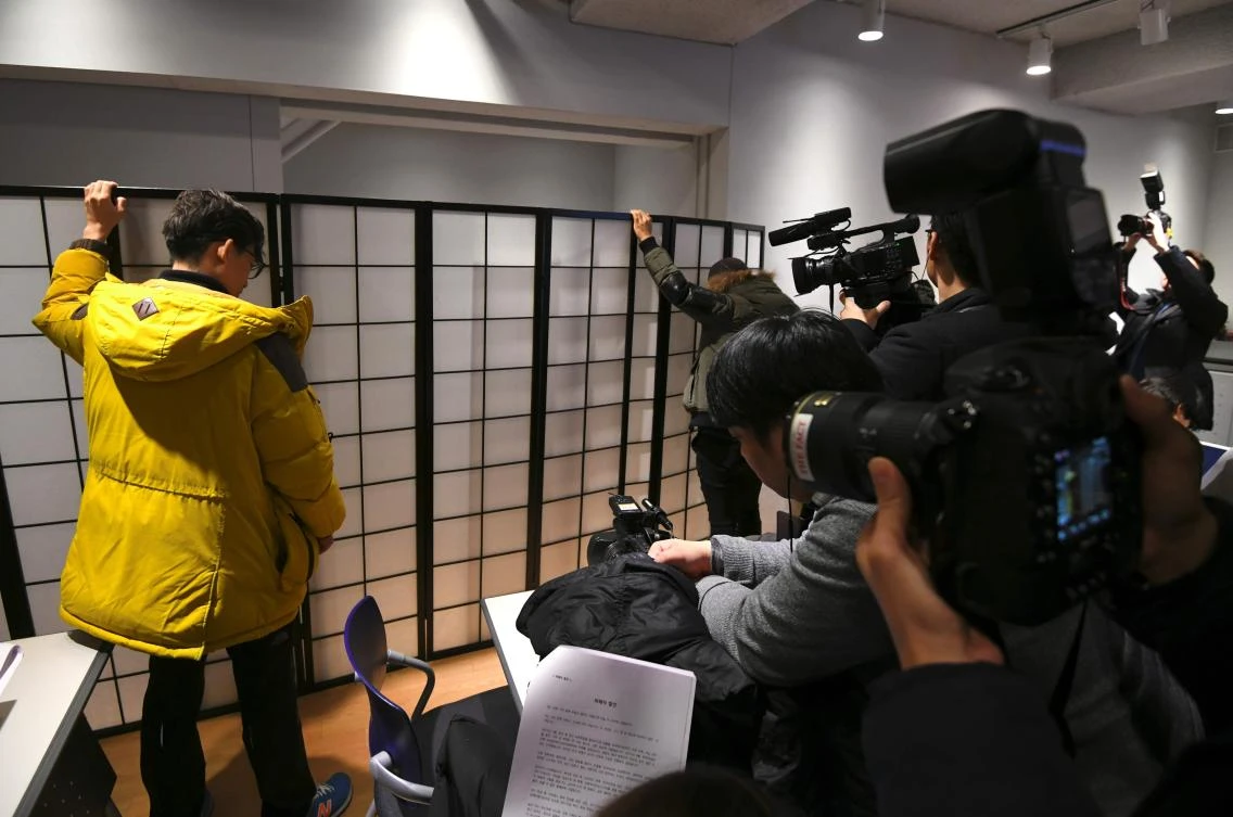 This file picture taken on December 14, 2017 shows staff members holding a white screen in Seoul while an anonymous South Korean actress speaks from behind the folding screen during a press conference accusing director Kim Ki-Duk of abusing her. (AFP)