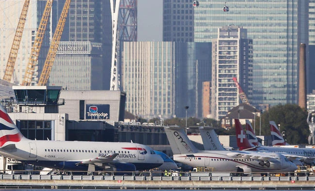 This file photo taken on October 27, 2017 shows British Airways airplanes on the runway with the towers and buildings of the Canary Wharf financial district in background before taking off at London City Airport in London. (AFP)