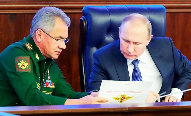 Russian President Vladimir Putin, right, and Defense Minister Sergey Shoigu talk to each other after visiting an exhibition at the Russian military's headquarters as part of a conference on the Russian campaign in Syria in Moscow, Russia, in this Jan. 30, 2018 photo. (AP)