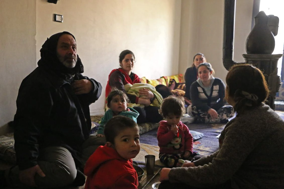 Members of seven displaced Syrian families gather in an apartment in the Kurdish Syrian town of Afrin on February 1, 2018 where they are all taking shelter after fleeing from a three-week assault by Turkey and allied Syrian rebels on towns and villages along the border in northern Syria. (AFP)