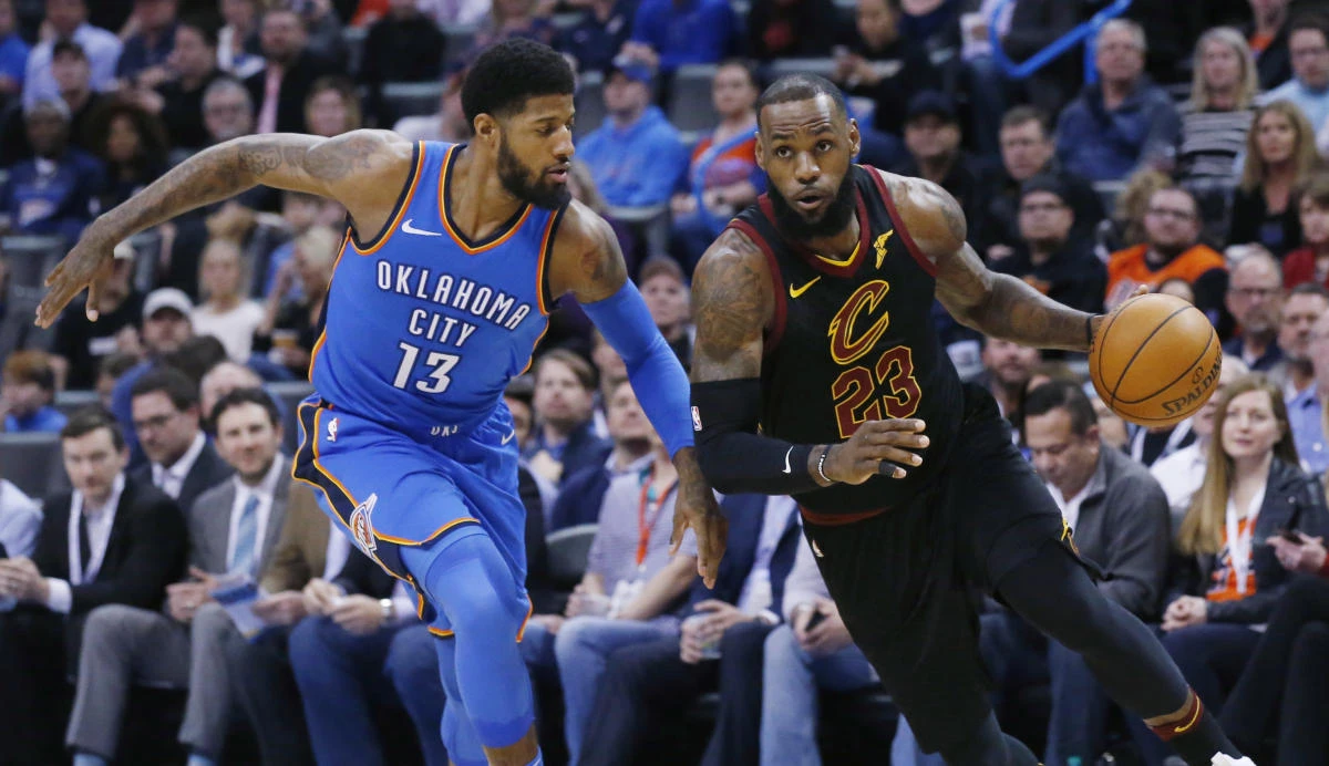 Cleveland Cavaliers forward LeBron James (23) drives past Oklahoma City Thunder forward Paul George (13) during the first half of an NBA basketball game in Oklahoma City, Tuesday, Feb. 13, 2018. (AP)