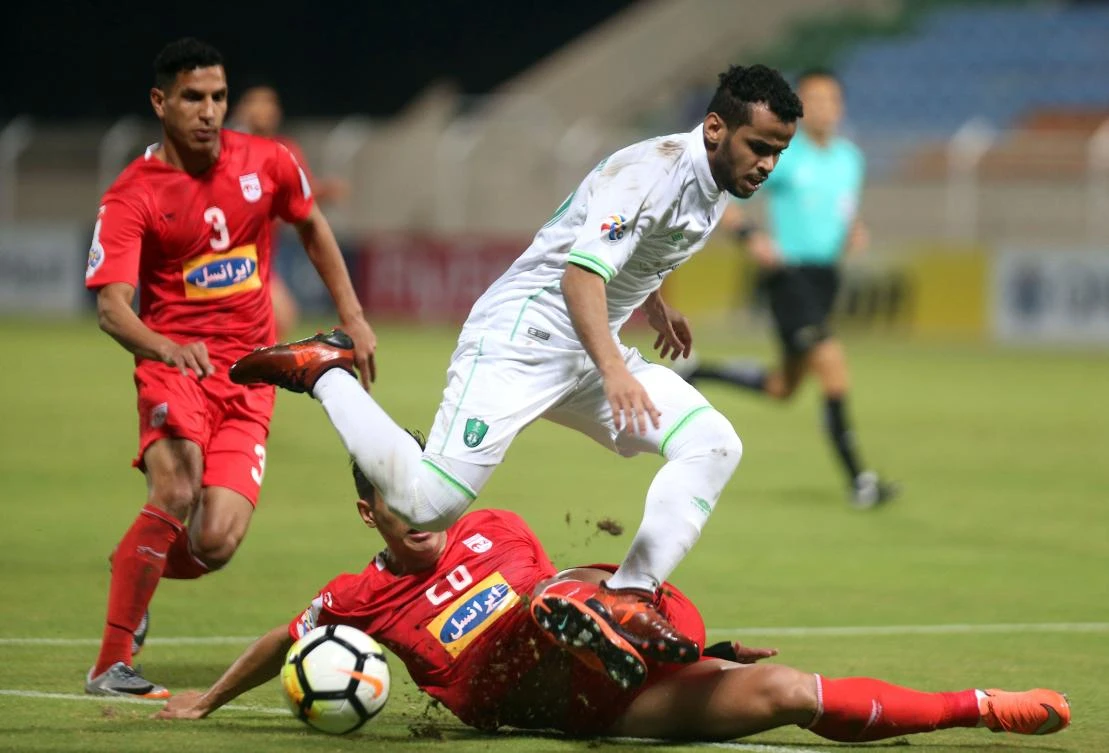 Al-Ahli's Abdulfattah Asiri fights for the ball with Tractor Sazi's Reza Sharbati (L) and Mohammed Naderi during their Asian Champions League match at the Al-Seeb stadium in Muscat. (AFP)